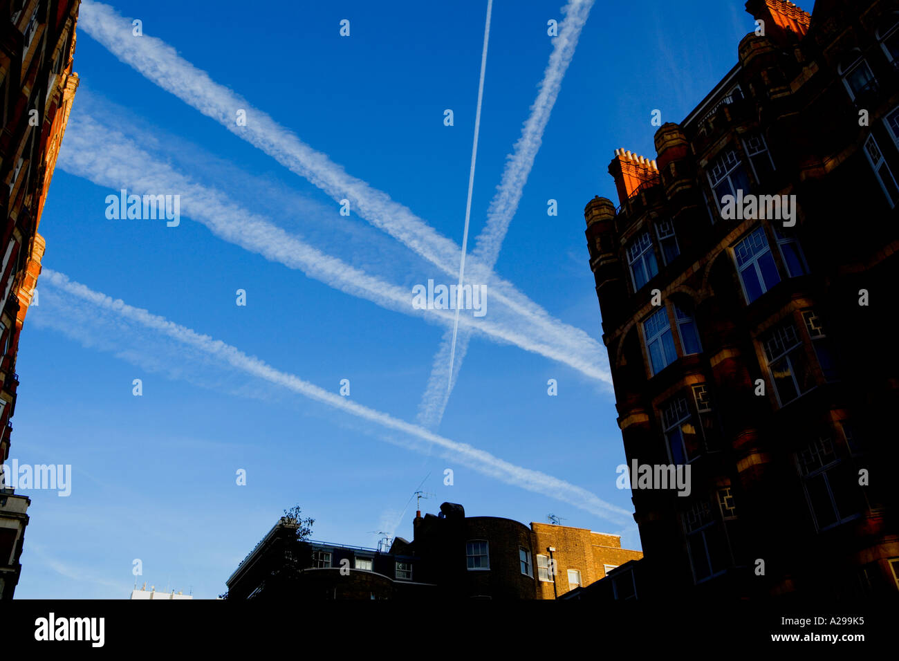 Busy London Skies. Vapor trails above central London. Stock Photo