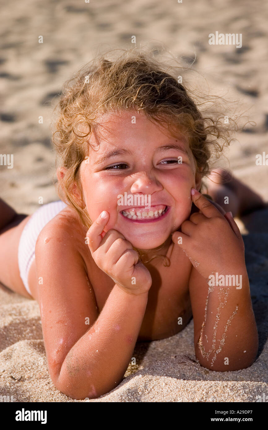 Portrait of a little girl amusing herself on the beach with sun burnt