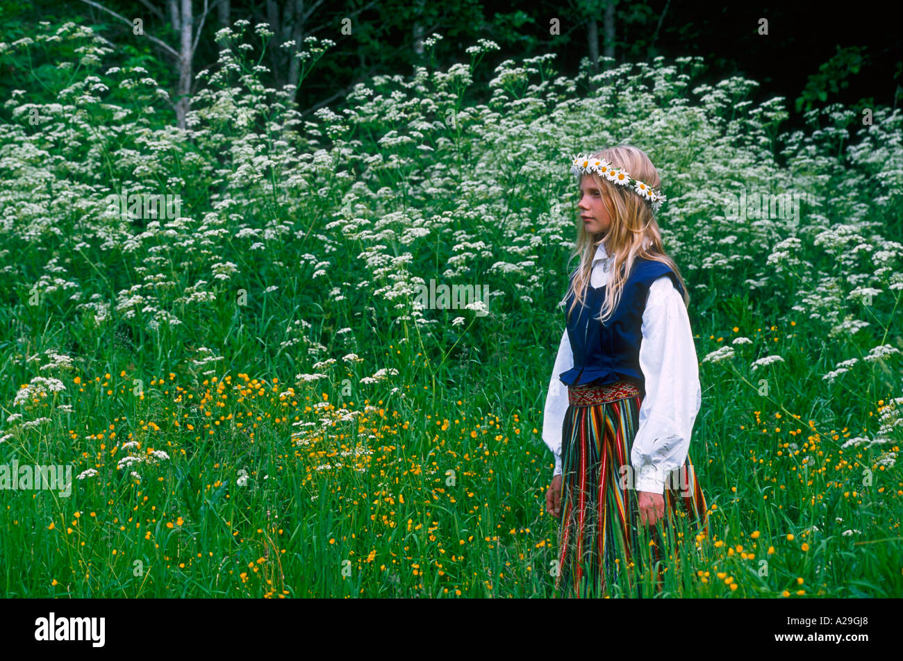 Estonian girl in traditional costume standing on the meadow Stock Photo