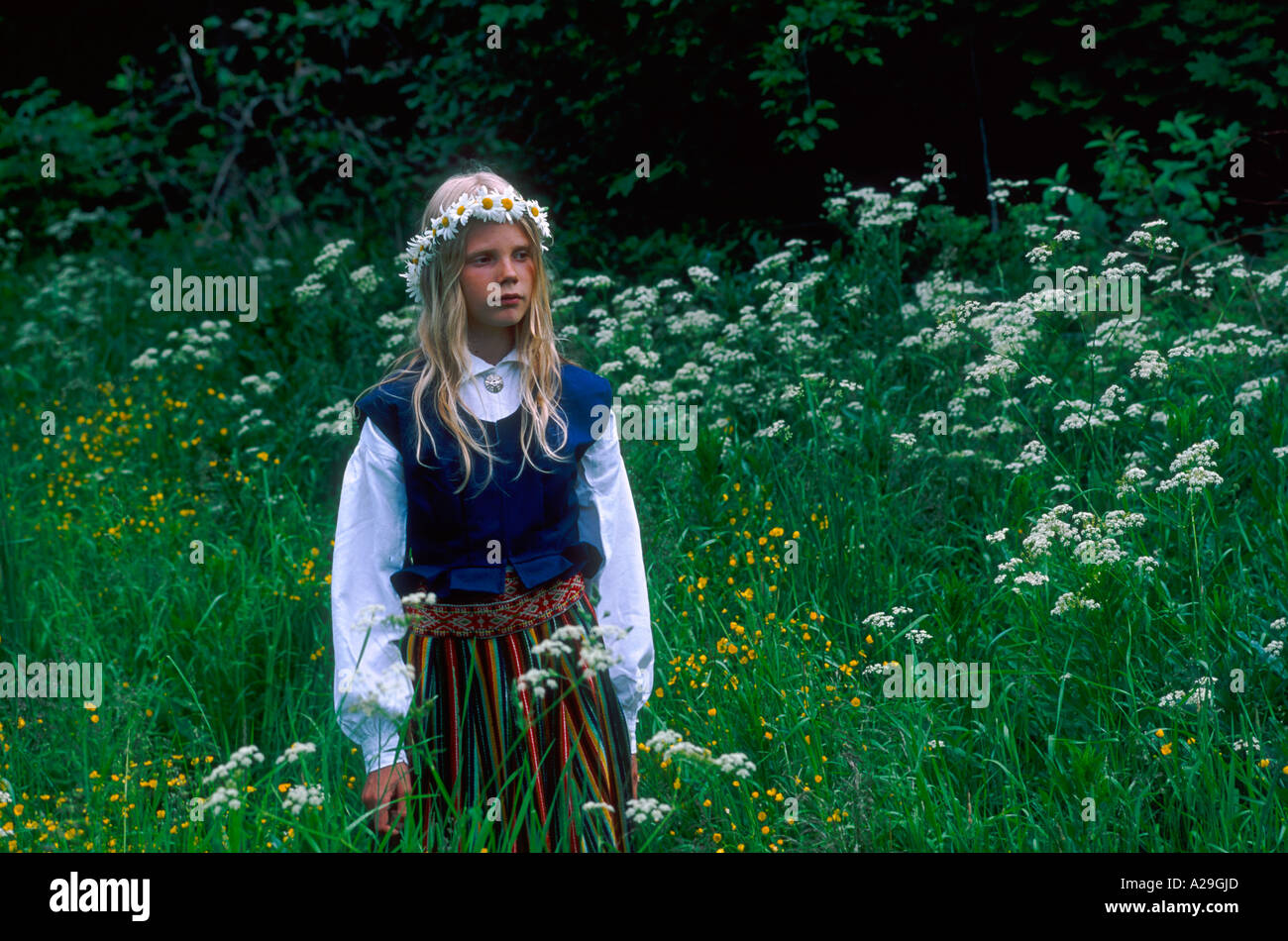 Estonian girl in traditional costume standing on the meadow Stock Photo