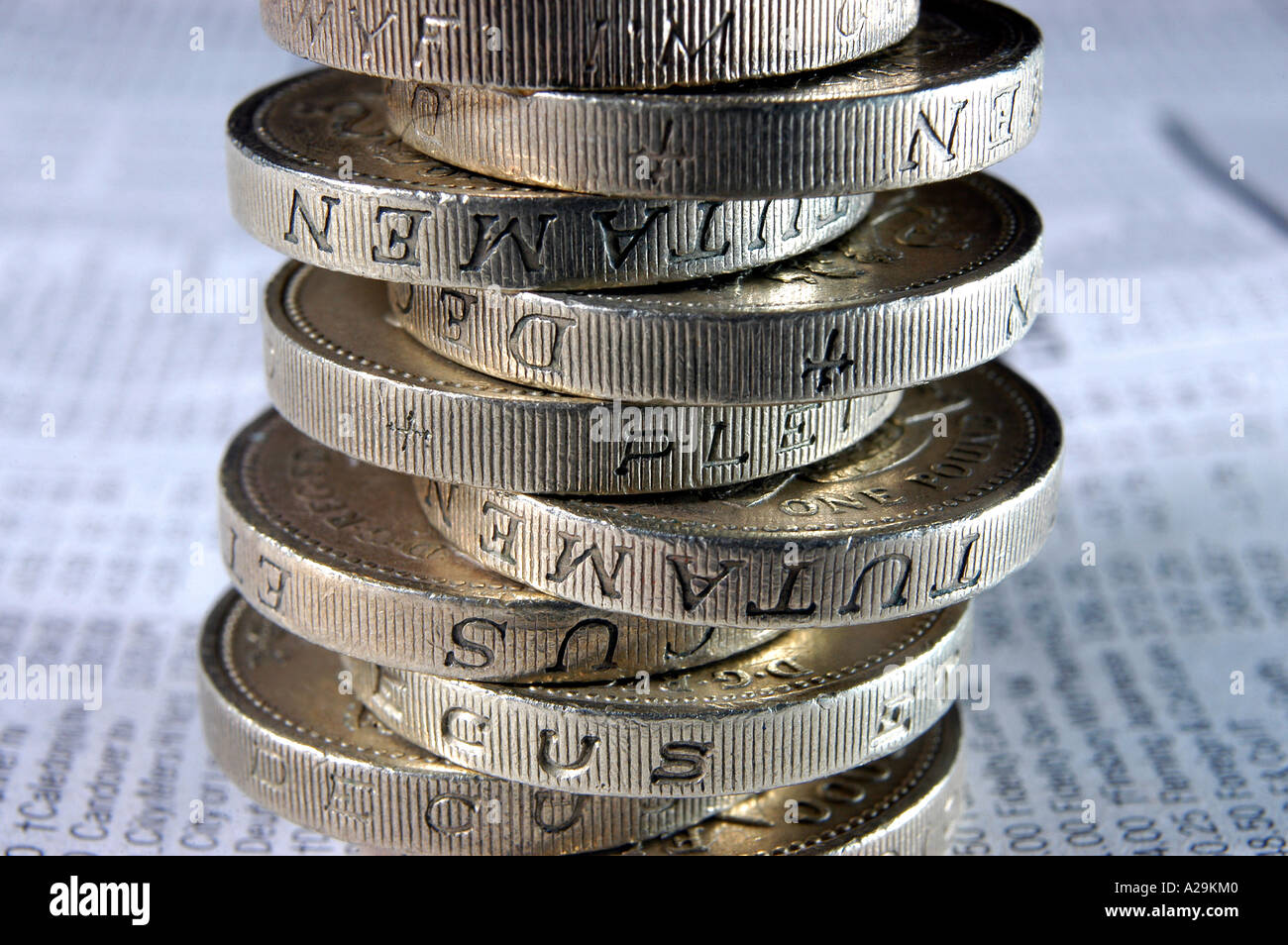 A stack of coins resting on the shares and investment pages of a newspaper. Illustrating credit crunch. Stock Photo
