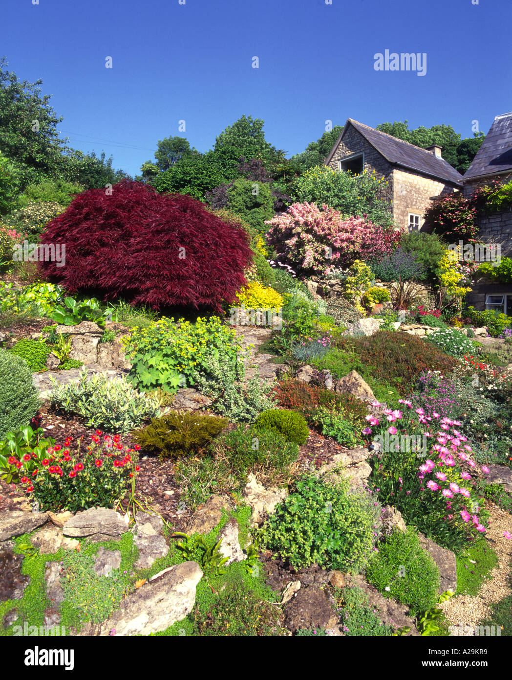 Hillside rockery style summer garden border Stock Photo - Alamy