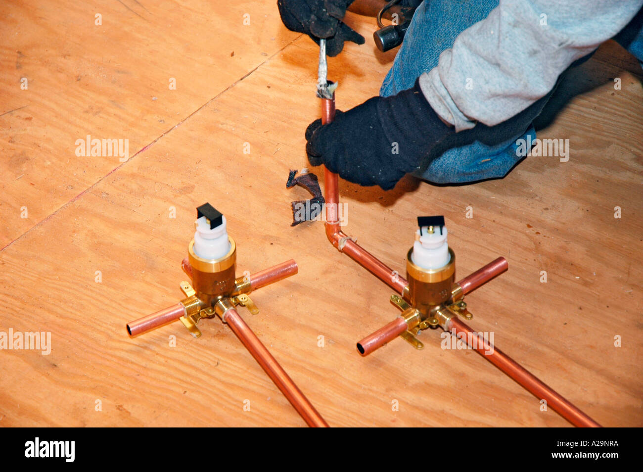 Plumbing installation crew putting in plastic and copper pipes into new home construction in USA