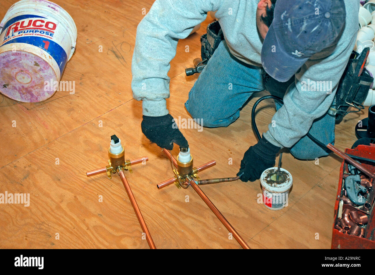 Plumbing installation crew putting in plastic and copper pipes into new home construction in USA