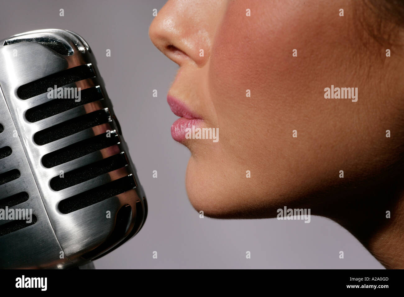 humming or singing into a fifties or sixties style microphone night nightime nightclub club bar Stock Photo