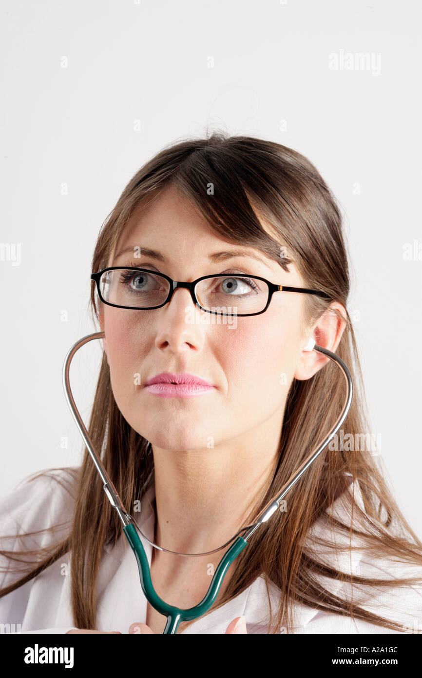 Young female doctor listening through a stethoscope Stock Photo
