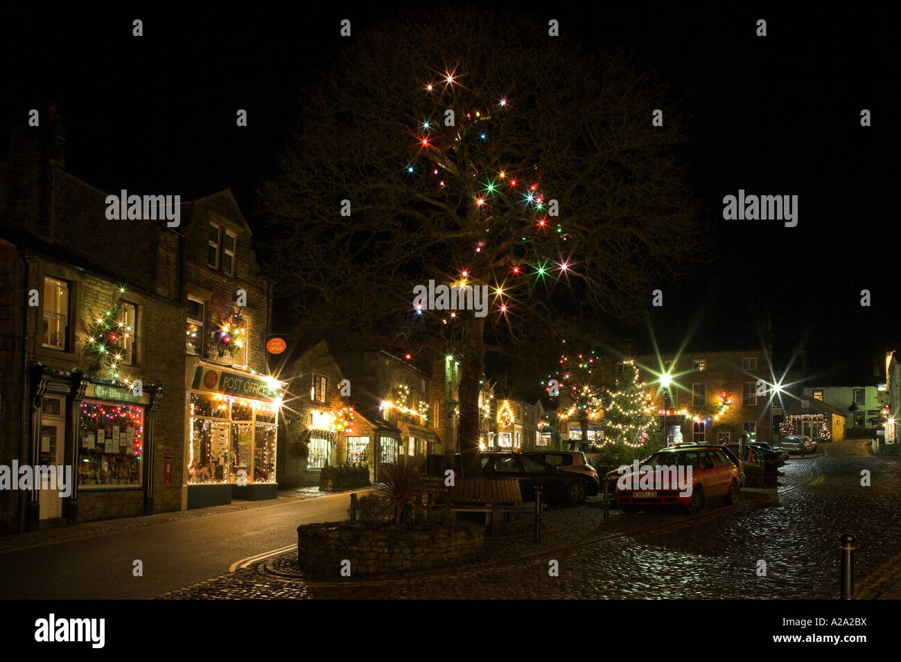 Colourful Christmas lights brighten up a dark winter's evening - Grassington Village, Yorkshire Dales National Park, England. Stock Photo