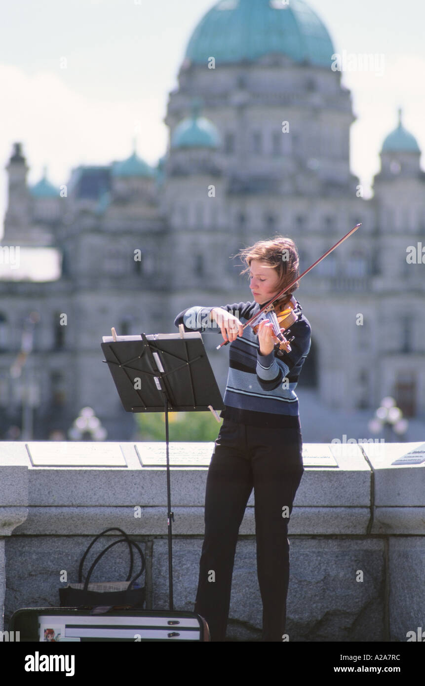 A violinist performs in front of the Parliament Building in Victoria