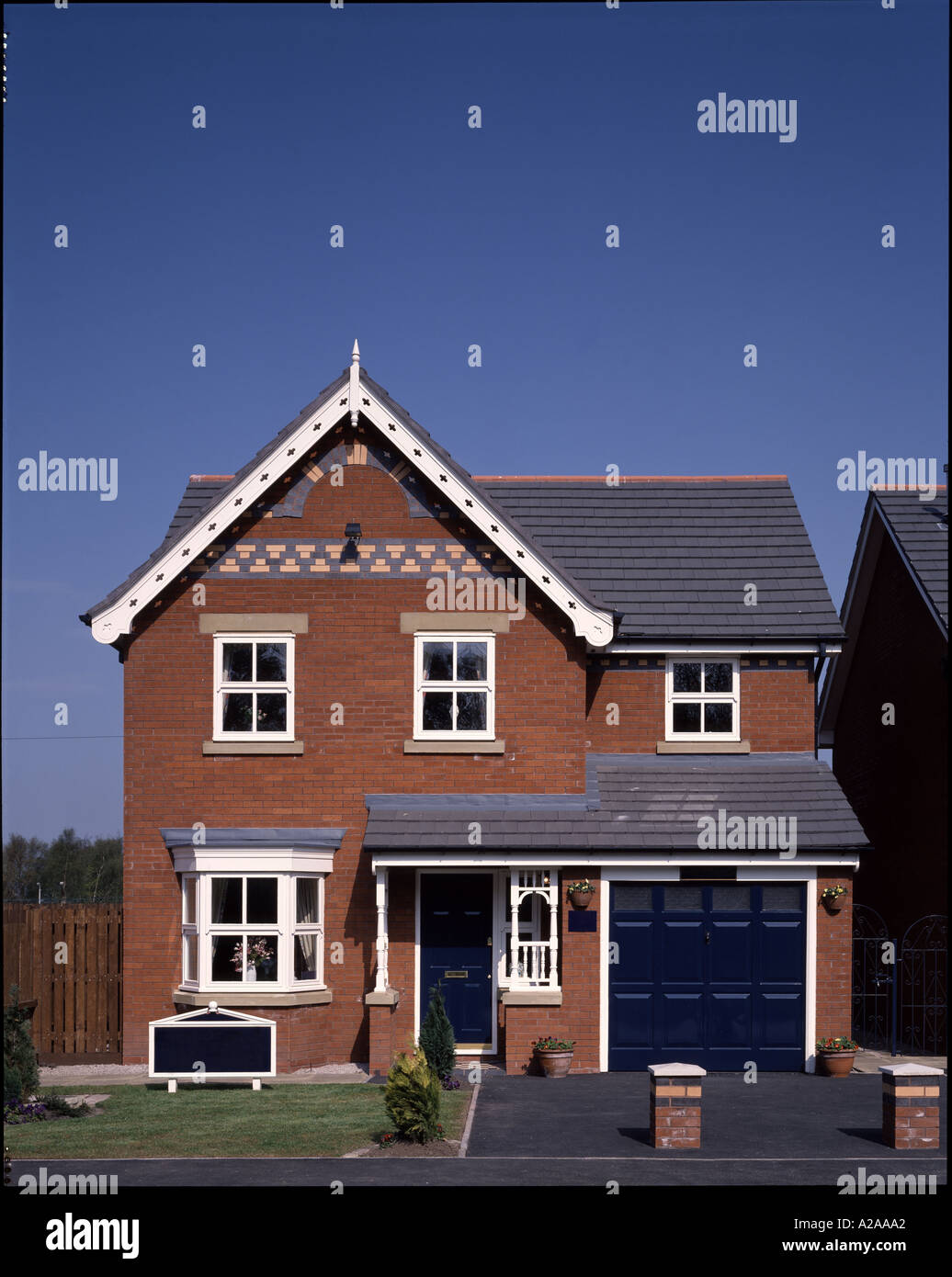 Front elevation of  ordinary red brick pitched roof executive house with integral garage. Architect: McLEAN HOMES Stock Photo