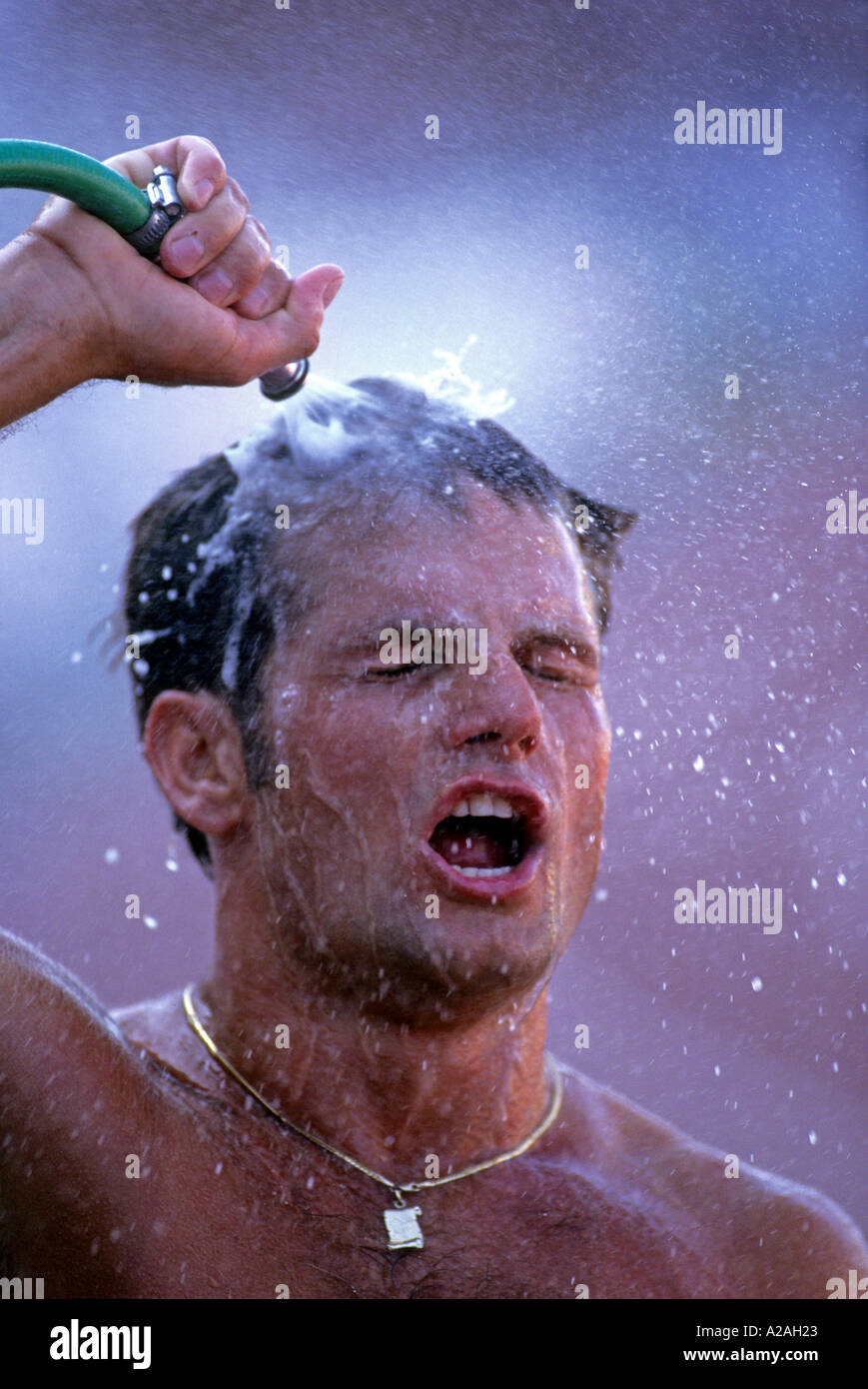 A Male Athlete Cools Down By Dousing Himself With Water From A Hose Stock Photo Alamy