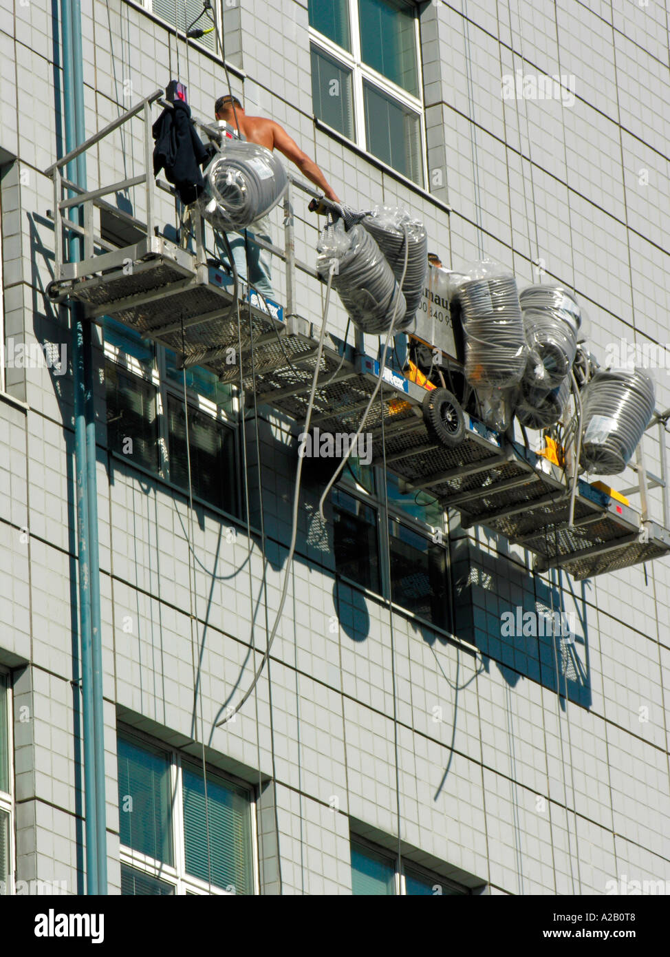 worker in a facade lift repair works on storefront facade of a multi ...