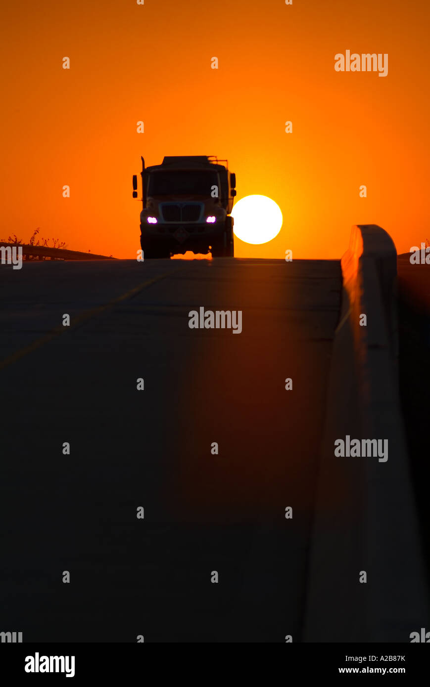 Truck Silhouette And Sun On Highway, USA Stock Photo