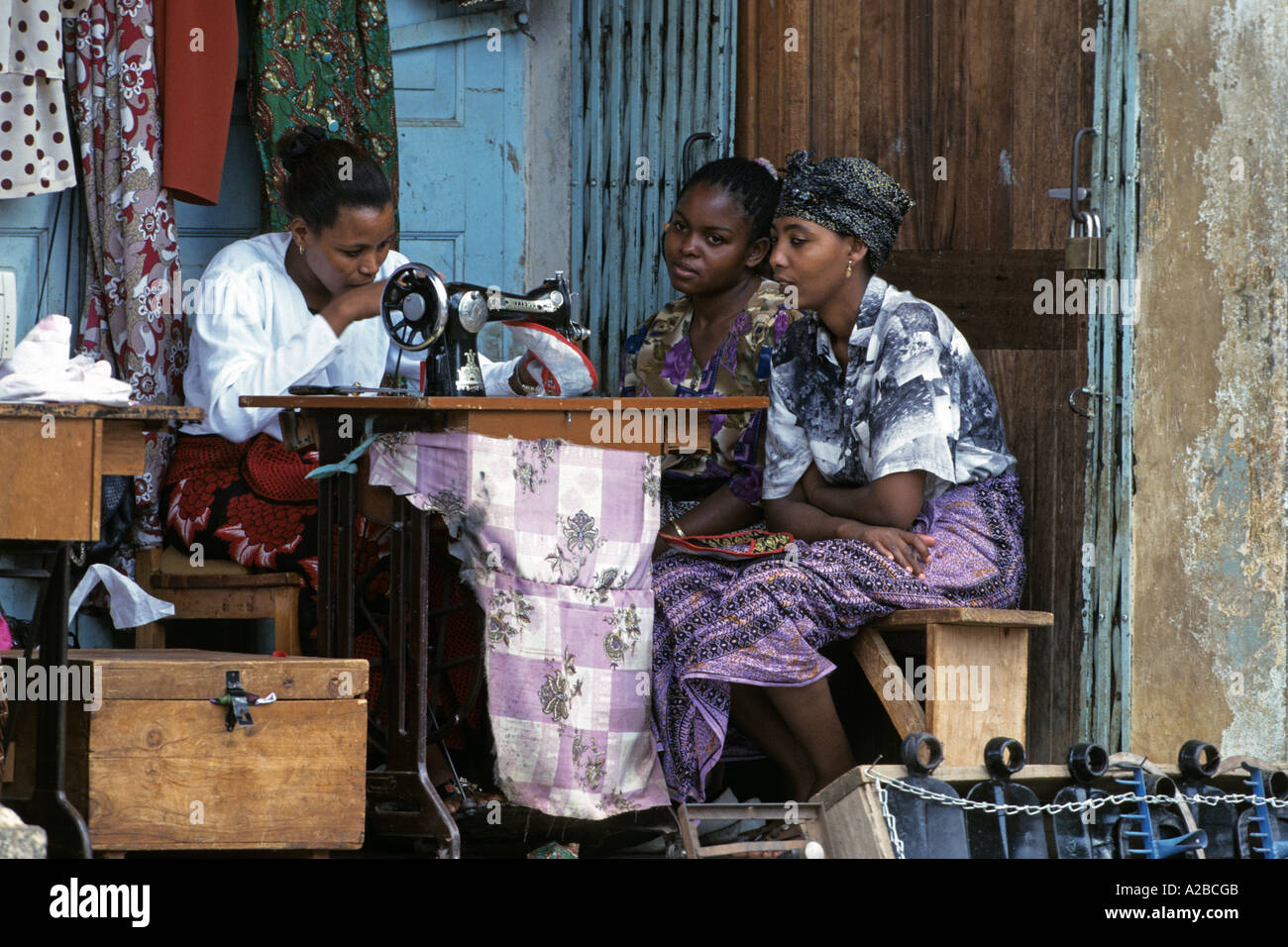 Female tailor with customers waiting and watching, Moshi; Tanzania Stock Photo