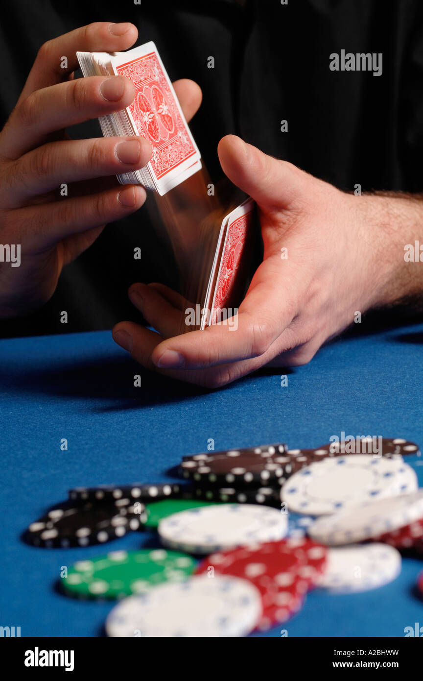 Young man shuffling cards at card table Stock Photo Alamy