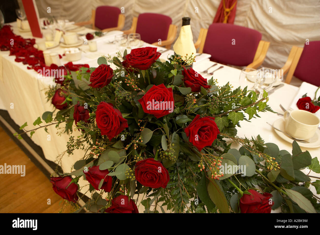 Red Roses And Petals Used To Decorate A Table At A Formal Wedding
