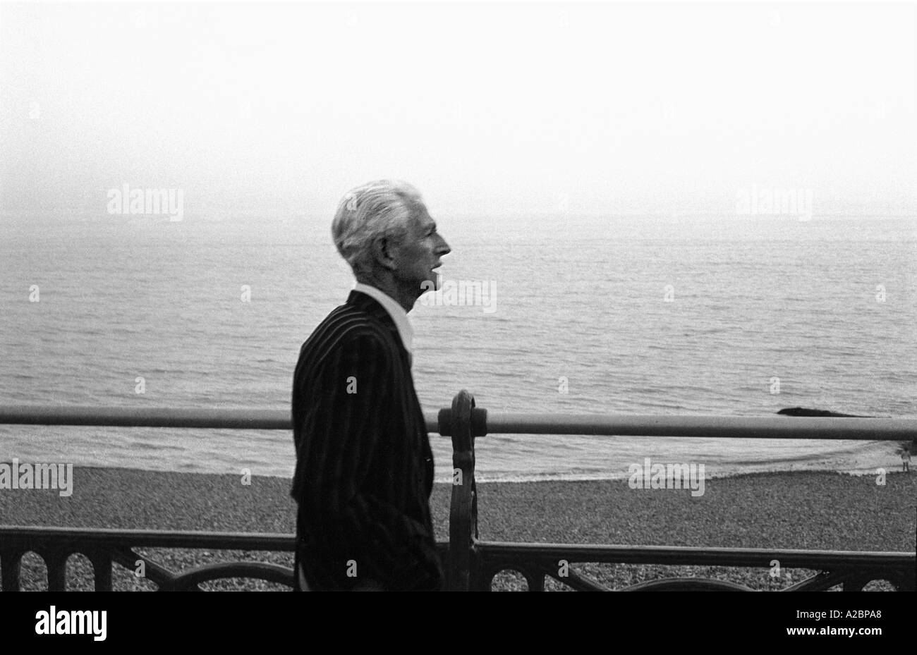 Retired man walking on sea front Brighton 1979 35mm b/w Stock Photo