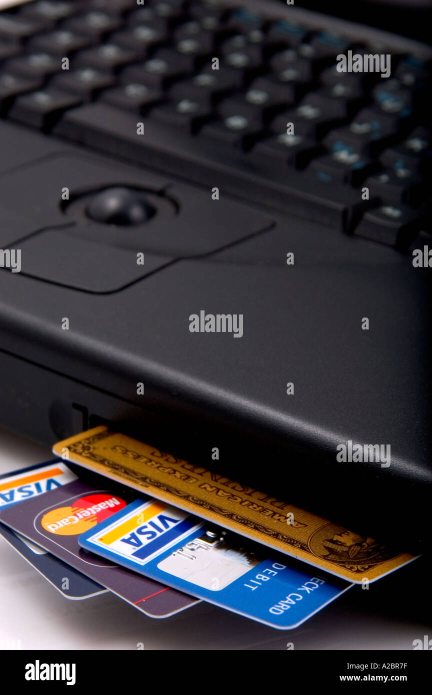 Laptop computer with various types of credit cards in drive slot Stock Photo