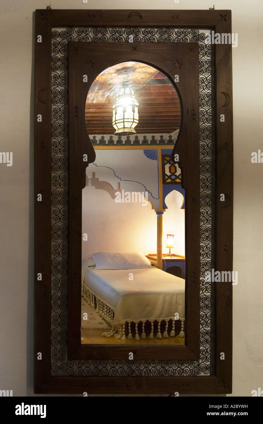 Bedroom view through wooden mirror at Casa Hassan restored traditional Moroccan Dar or guesthouse Chefchaouen Morocco Stock Photo