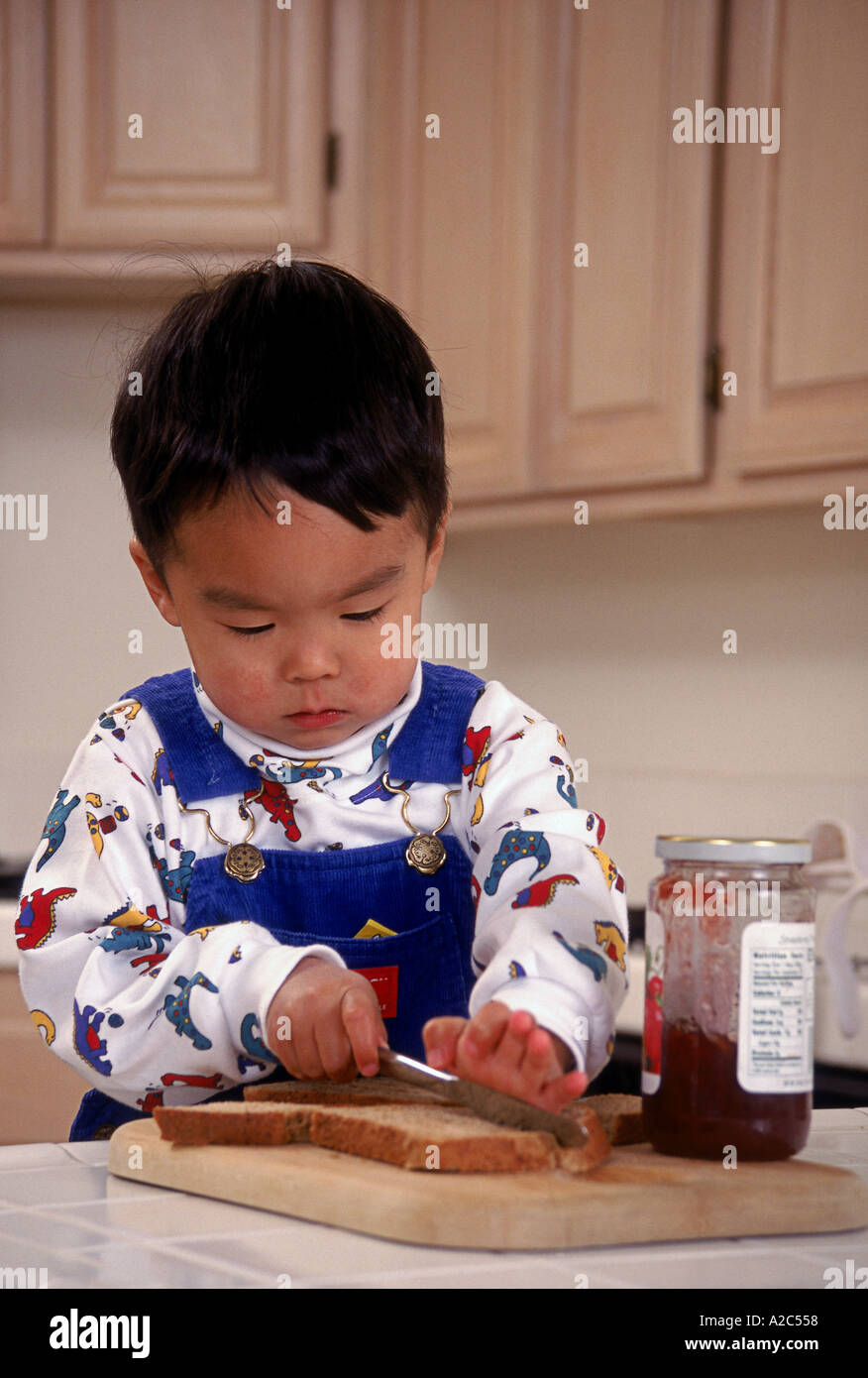 Japanese American pre-k 3 -4 year old at home learning to make a sandwich   POV  MR  © Myrleen Pearson Stock Photo