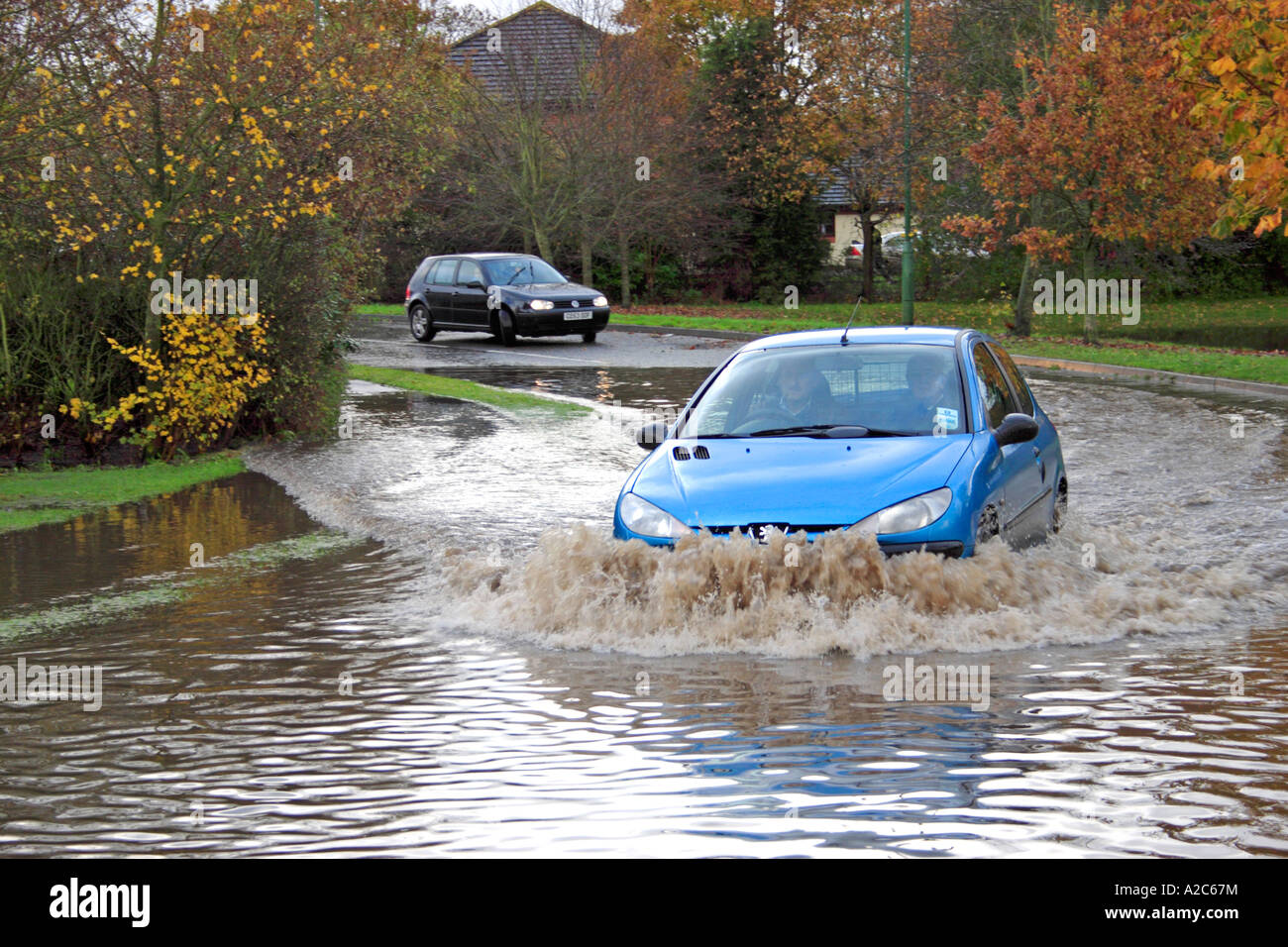 Cars driving through flooded road Stock Photo
