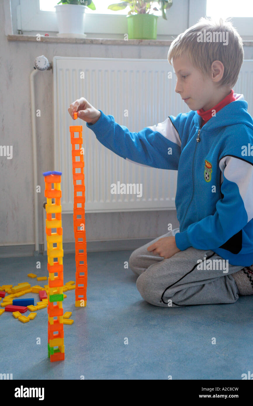 young boy building towers from dominos Stock Photo Alamy