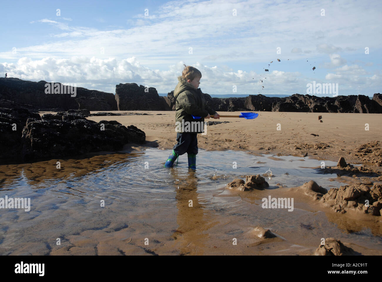 A young boy digging in the sand with a bucket and spade on Croyde Beach