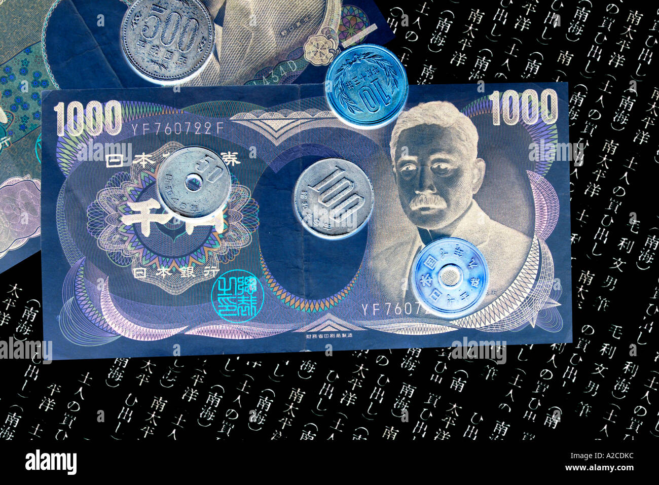 A concept image of Japanese 1000 Yen notes and coins against a reversed written background. Stock Photo