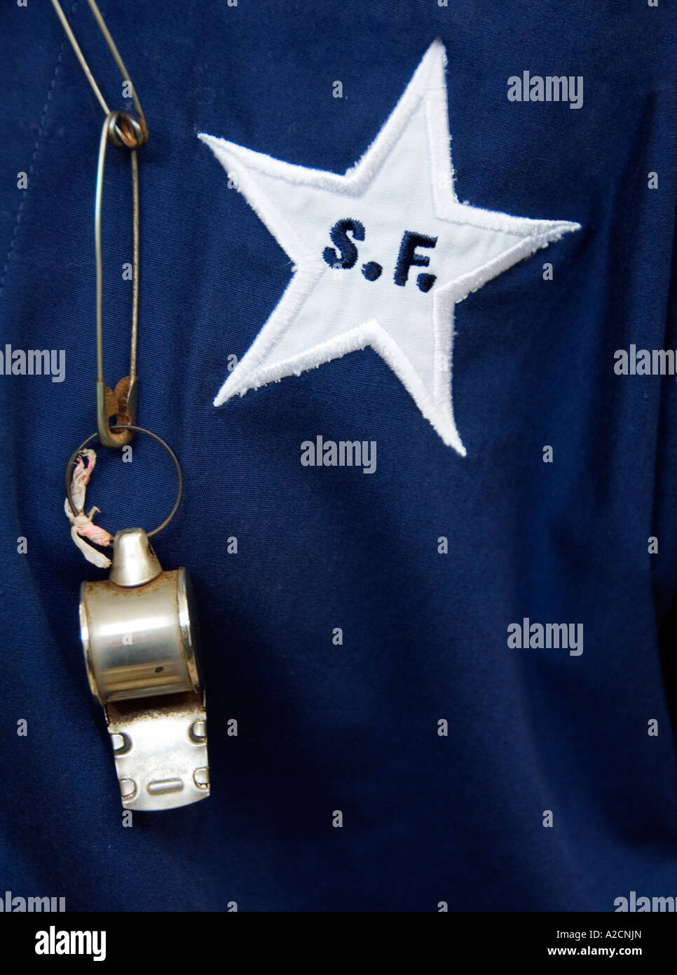 detail of uniform of Hong Kong Star Ferry worker with badge logo and whistle Stock Photo