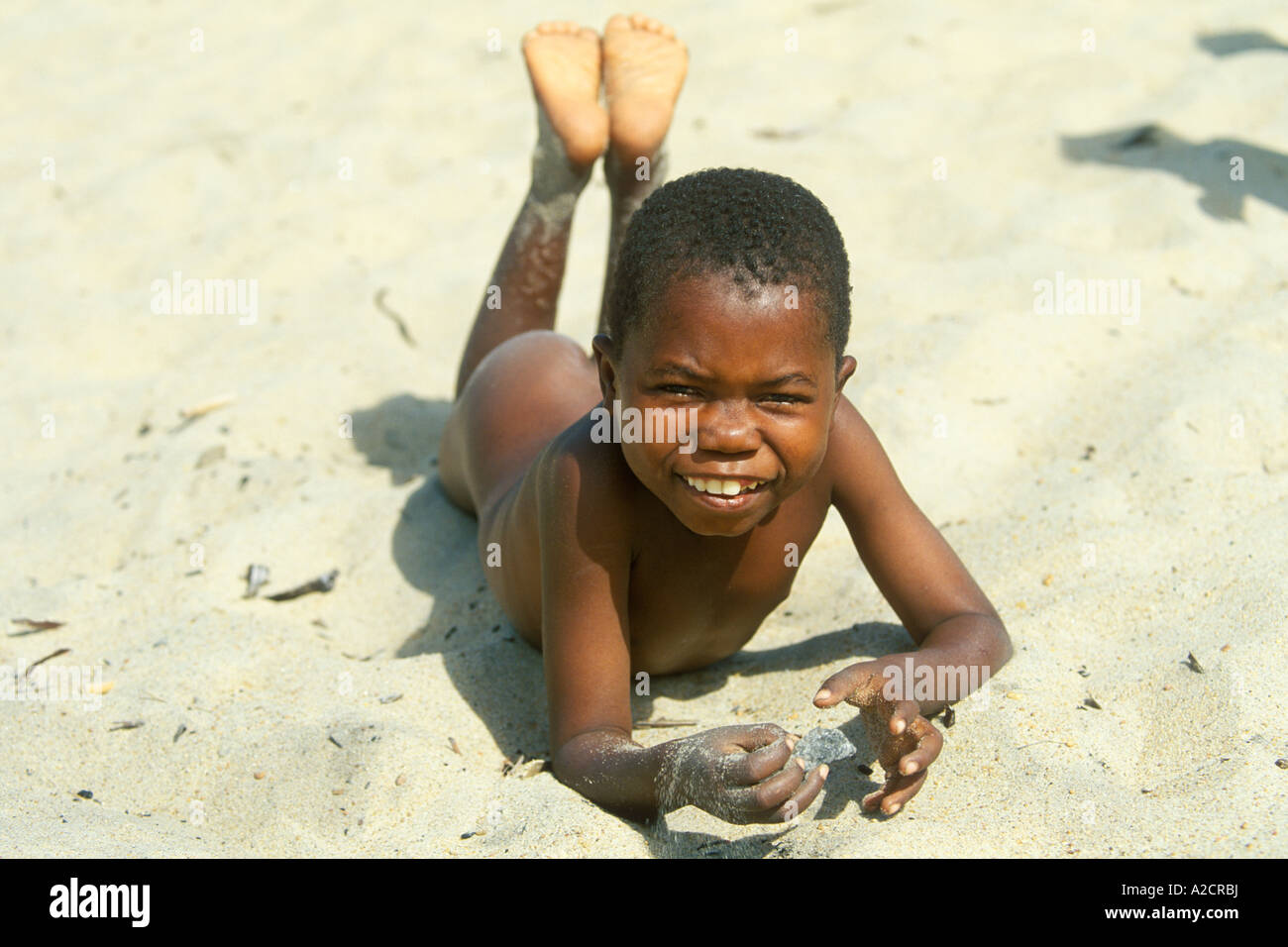 a smiling native boy lying in the sand at Kande Beach at Lake Malawi in  Africa Stock Photo - Alamy