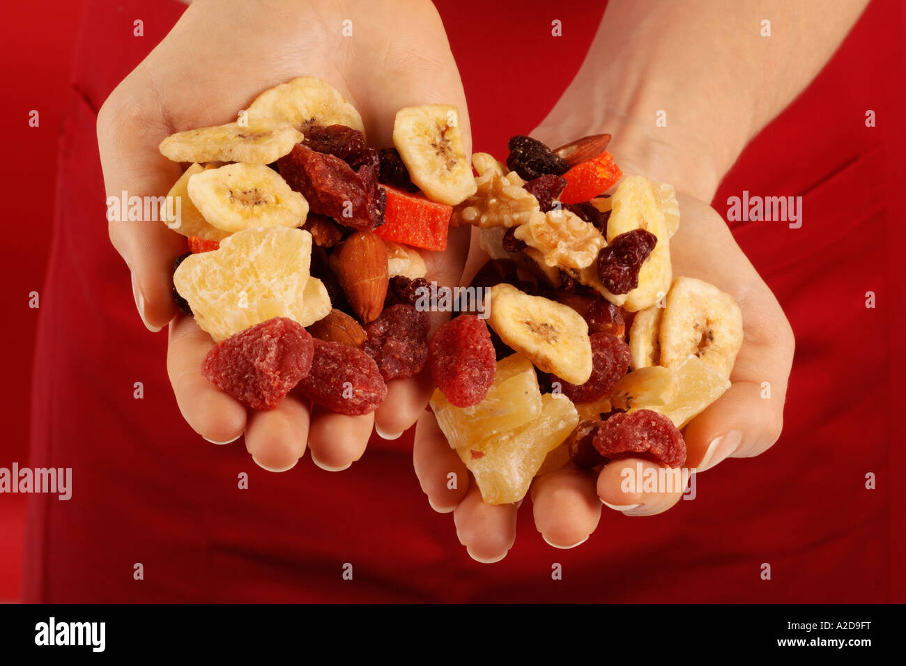 WOMAN HOLDING HANDFUL OF DRIED FRUIT AND NUTS Stock Photo