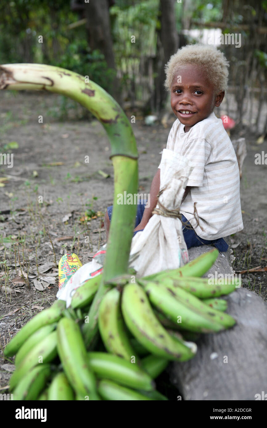 Young Tolai boy sitting with a large bunch of bananas, Matupit Island, East New Britain, Papua New Guinea Stock Photo