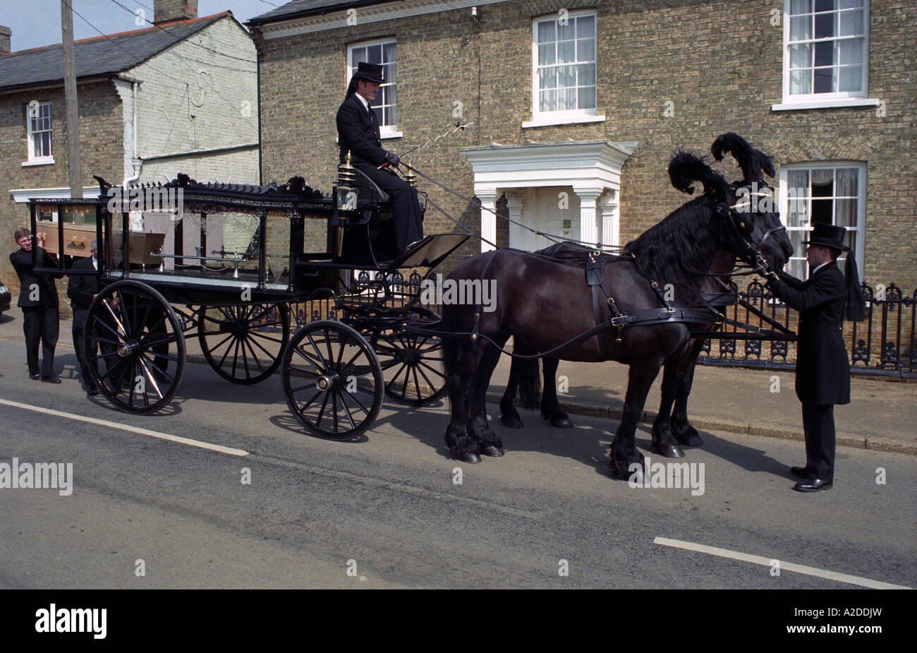 Horse drawn hearse outside a family funeral directors in Alderton near Woodbridge, Suffolk, UK. Stock Photo