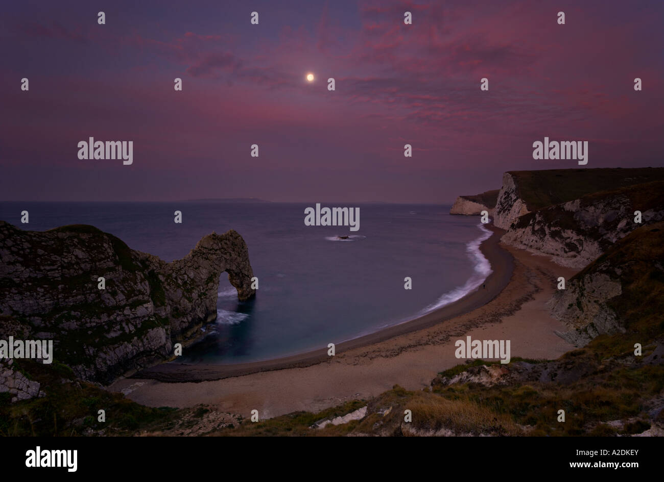 Durdle Door at Dawn with Moon Stock Photo