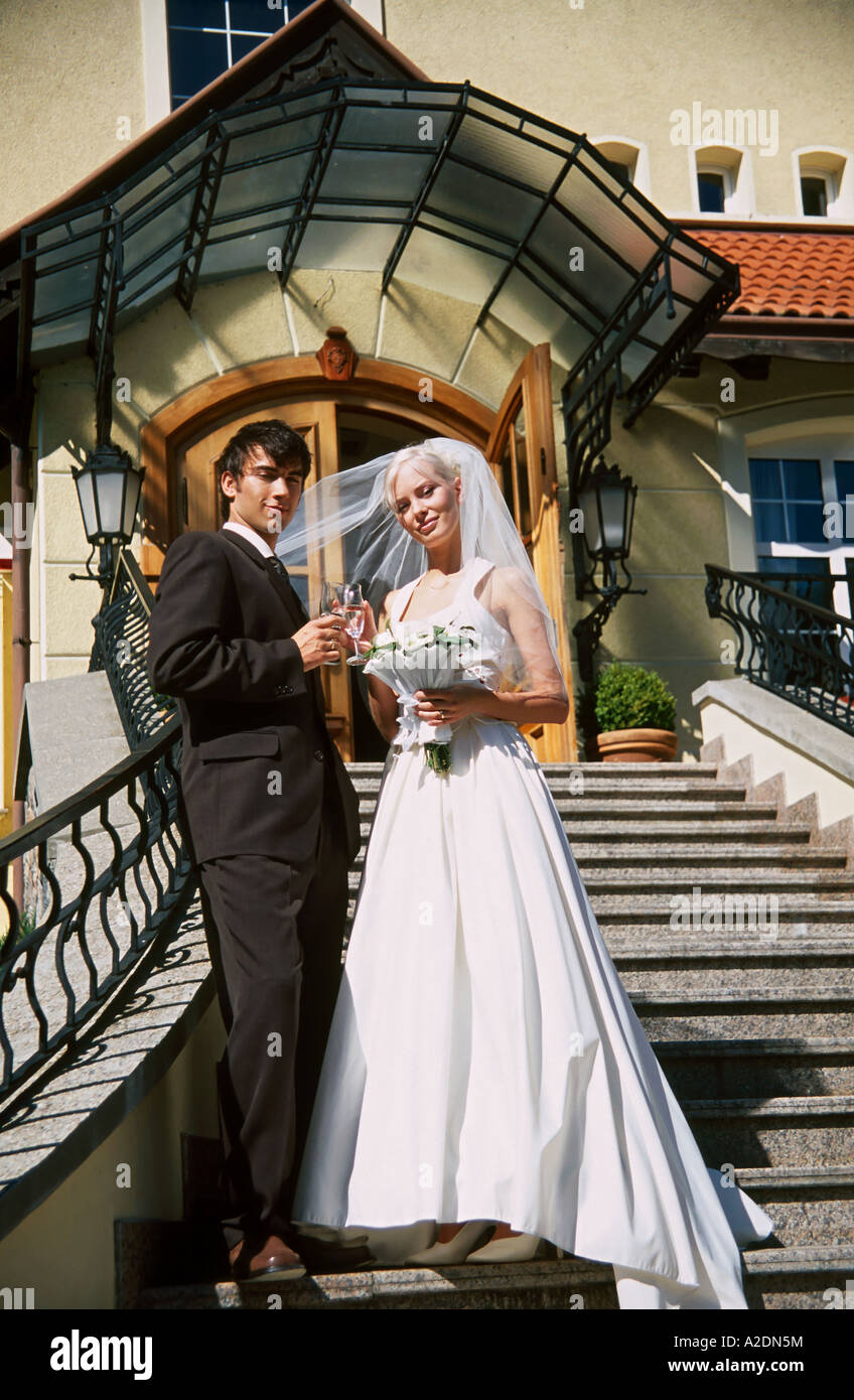 1207917 outdoor day summer church stairs couple marriage wedding newlyweds man woman young 25 30 blonde dark haired dress wed Stock Photo