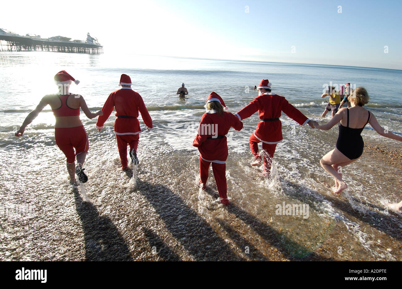 Hardy swimmers dressed in Santa suits take part in the annual Christmas Day Dip in the sea at Brighton on a sunny Xmas morning Stock Photo