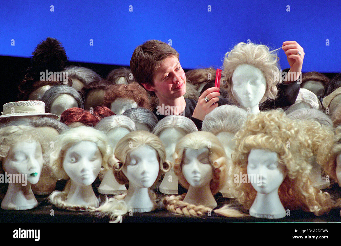 An opera company wig mistress titivates one of the many wigs used in every performance. Stock Photo