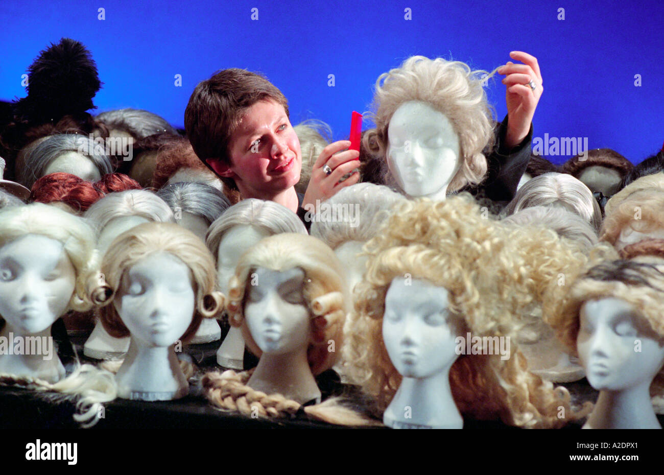 An opera company wig mistress titivates one of the many wigs used in every performance. Stock Photo