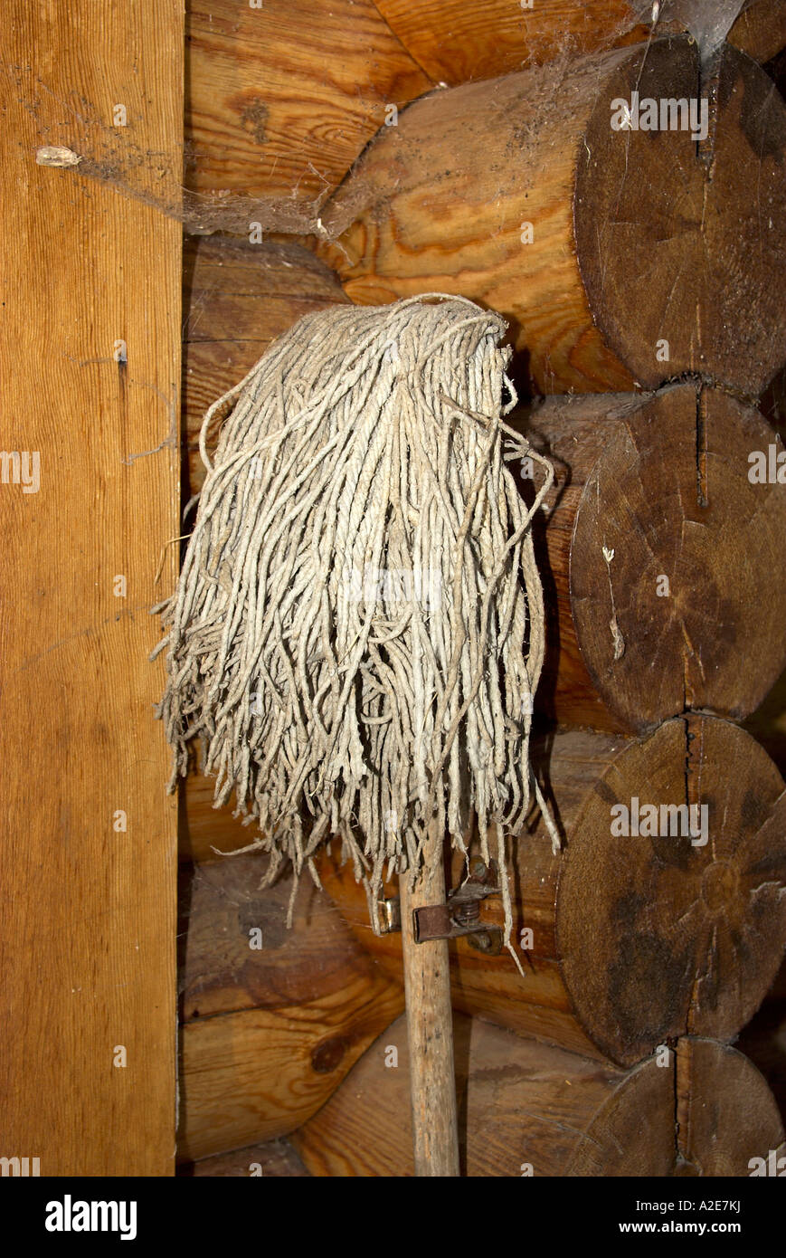Old mop hanging on a log house Stock Photo - Alamy