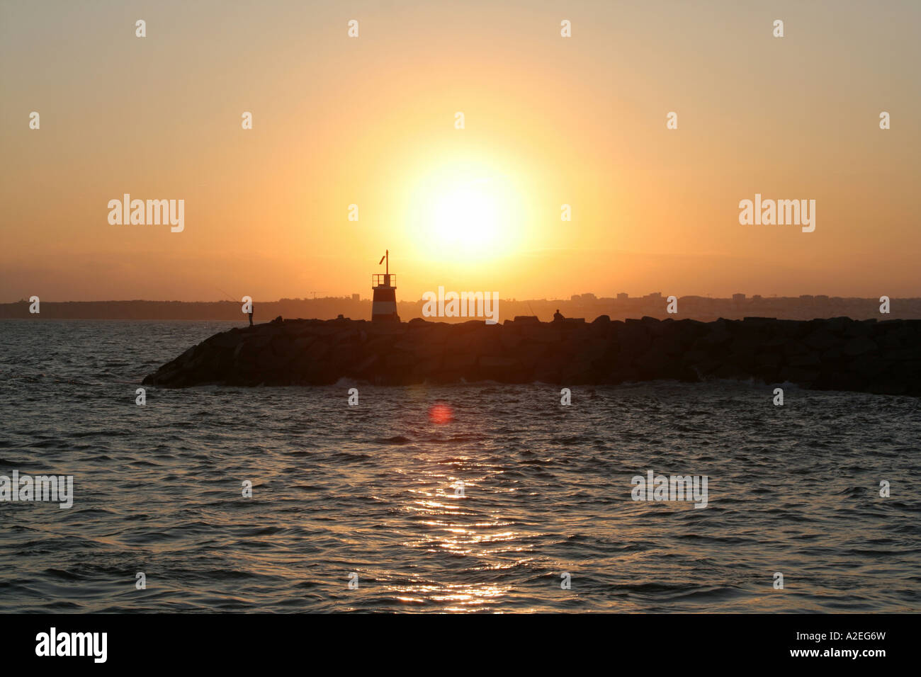 the lighthouse Alvor in the evening sun Lagos city in the background Algarve Portugal Stock Photo