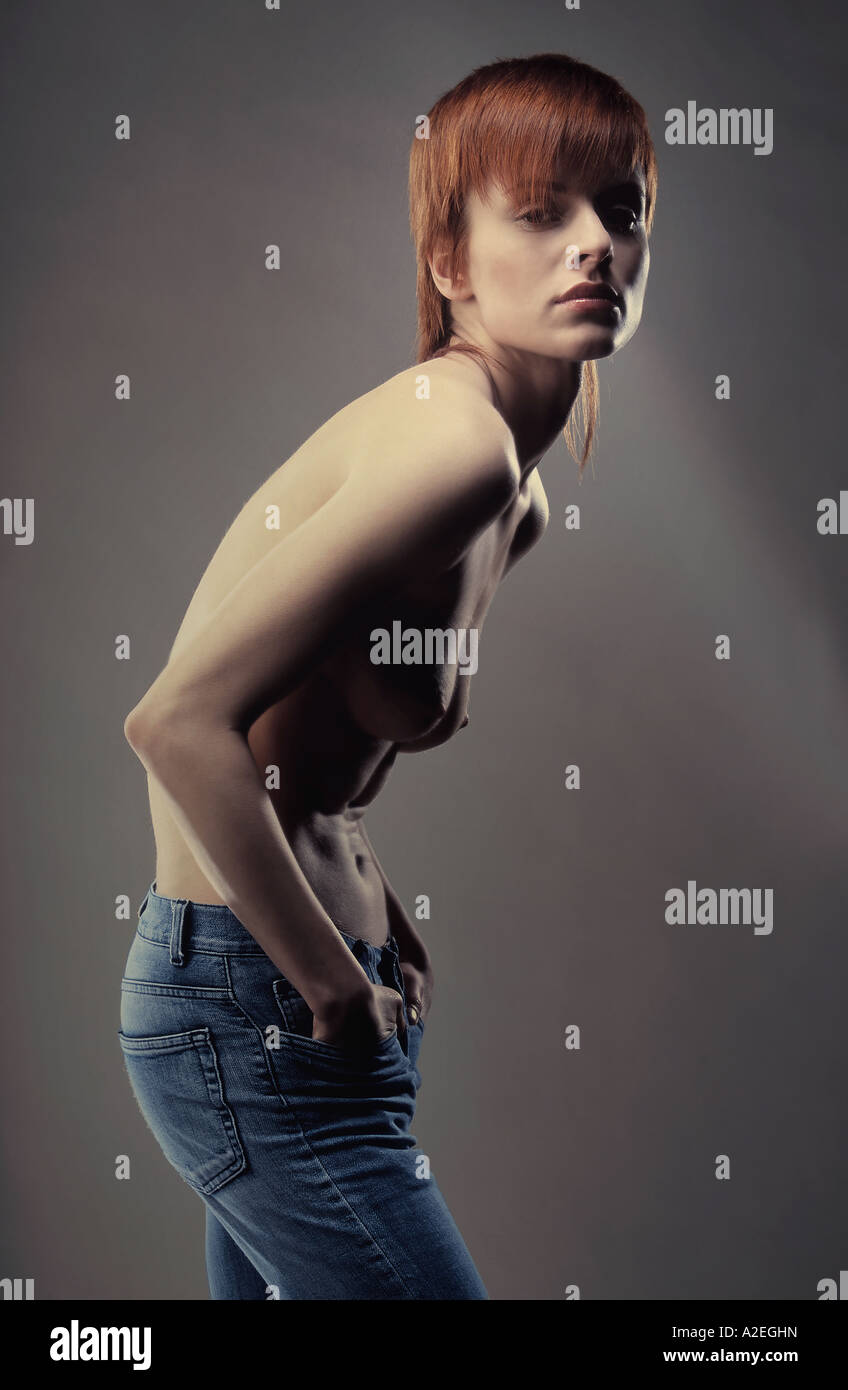1218389 indoor studio woman young redhead 20 25 girl forelock naked  nakedness body stand breast bust profile jeans trouse Stock Photo - Alamy