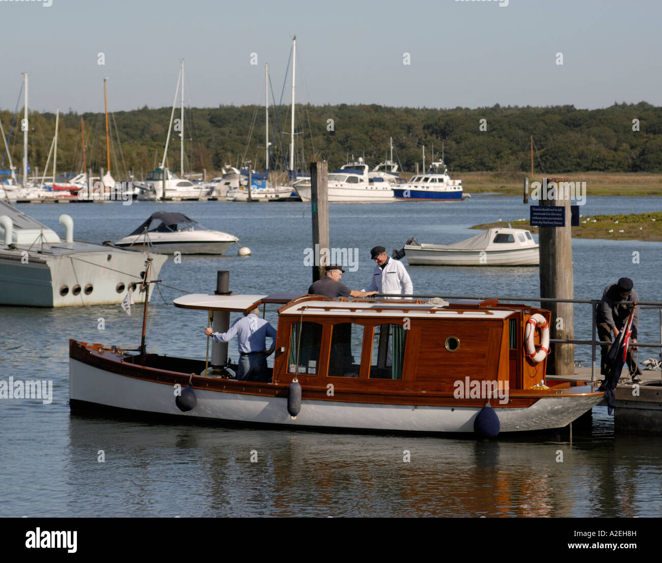 A steam launch tied up to a jetty being prepared for a trip on the tidal reaches of the Beaulieu River Stock Photo