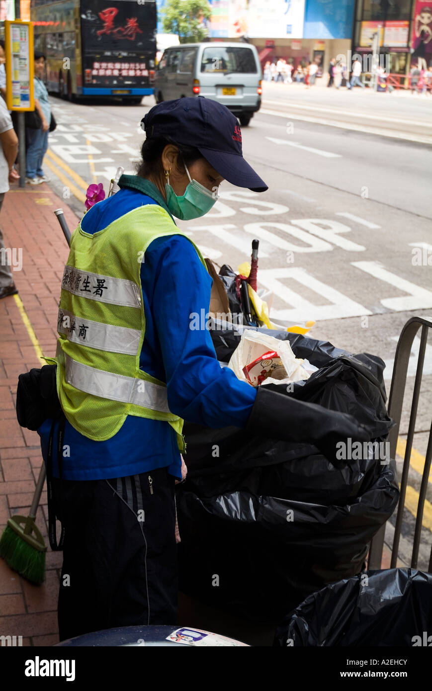 dh  CAUSEWAY BAY HONG KONG Young girl dustbin collector with hygiene mask dust bin collection people wearing masks Stock Photo