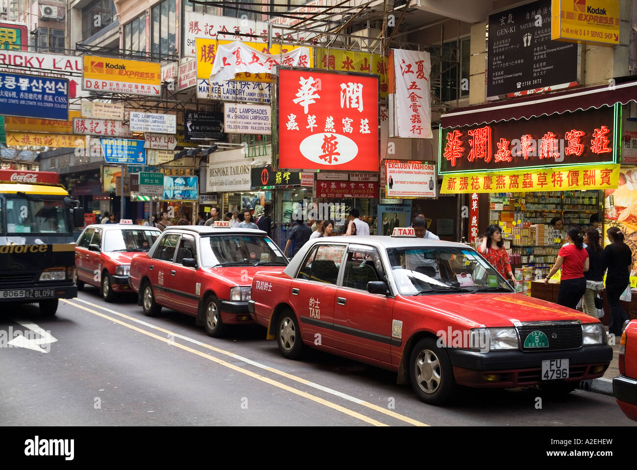 dh  TSIM SHA TSUI HONG KONG Line of Red Taxis in Haiphong Road taxicabs street cabs taxi streets Stock Photo