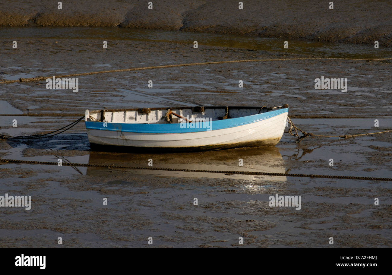 A traditional clinker built rowing boat moored on the mud near Lymington Stock Photo