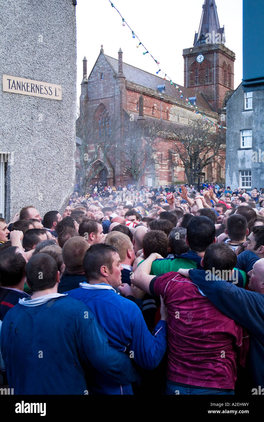 dh New Years day KIRKWALL ORKNEY Pack of Ba players and St Magnus Cathedral ball game football street people scotland Stock Photo