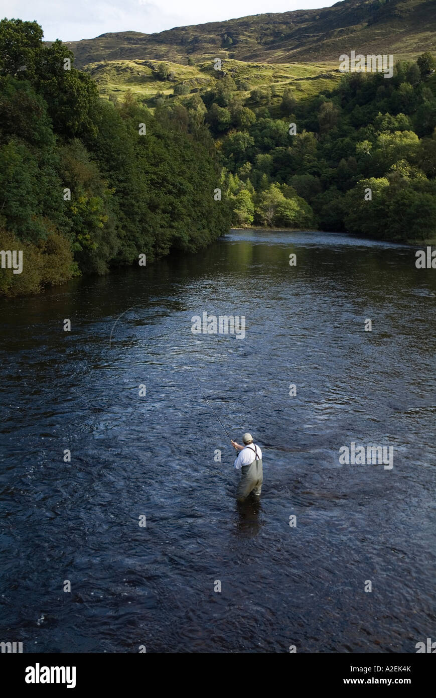 dh River Lyon GLEN LYON PERTHSHIRE Fisherman waders standing in water flyfish angling angler casting reel fish rod scotland fly fishing Stock Photo