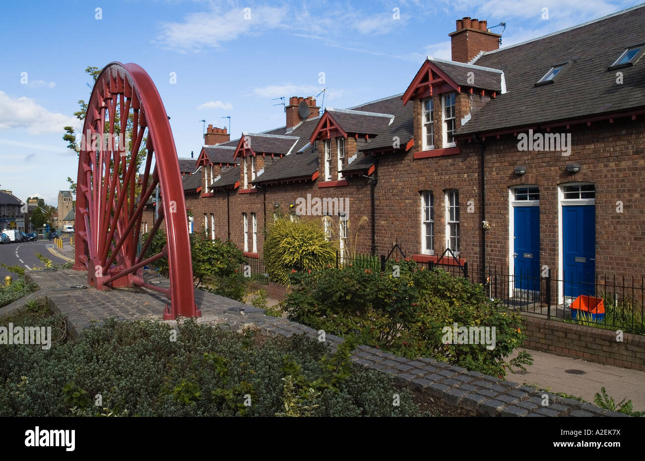 dh  NEWTONGRANGE LOTHIAN Traditional miners terraced town houses and pithead wheel scotland scottish house village uk Stock Photo