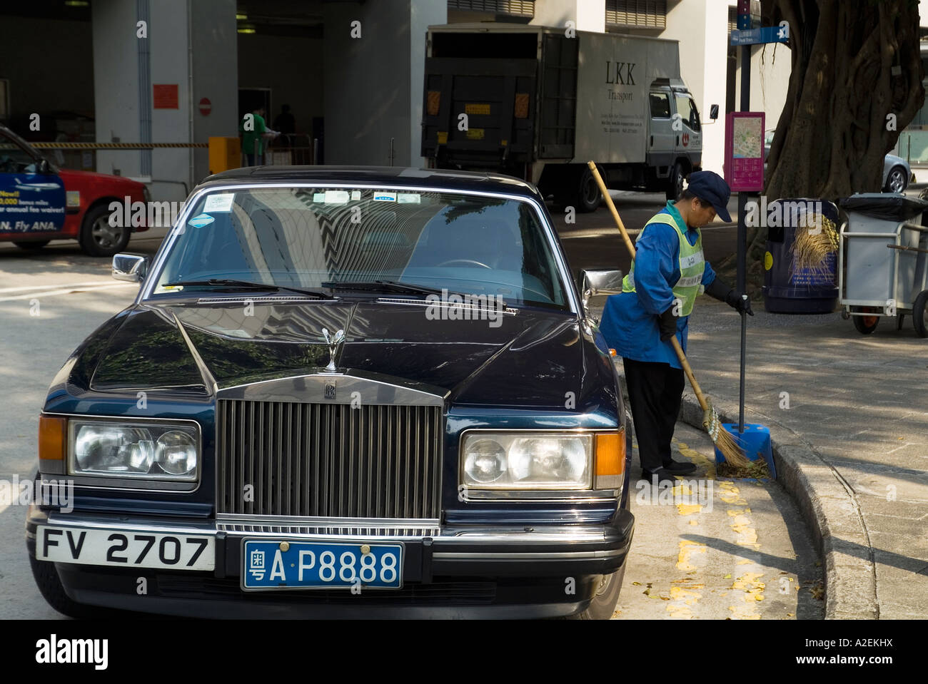 dh CENTRAL HONG KONG Rolls Royce Chinese licence plates street cleaner luxury car expensive china rich poor wealth gap wealthy cars asia inequality Stock Photo