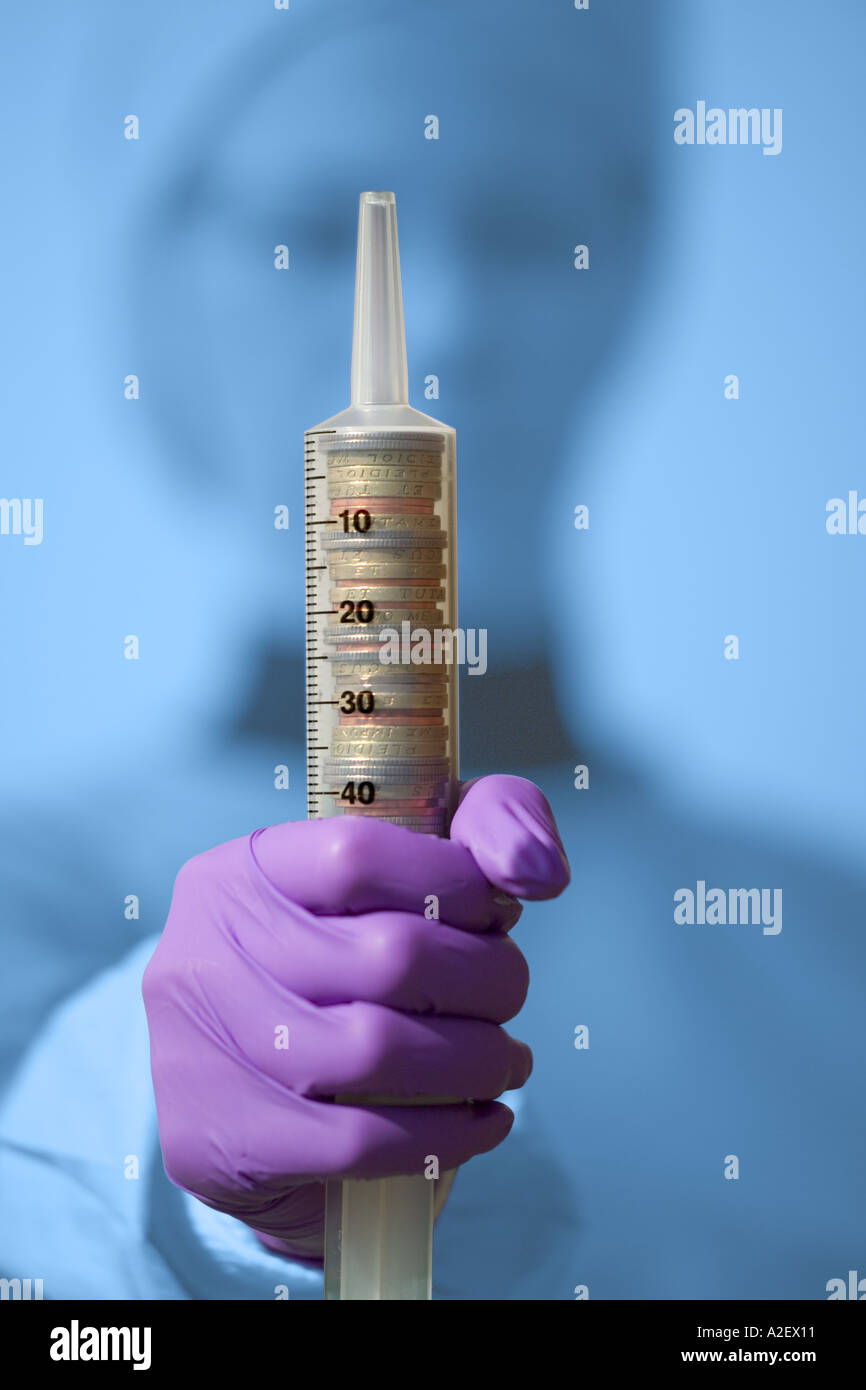 Medical NHS Cash injection coins in syringe held by medic Stock Photo ...