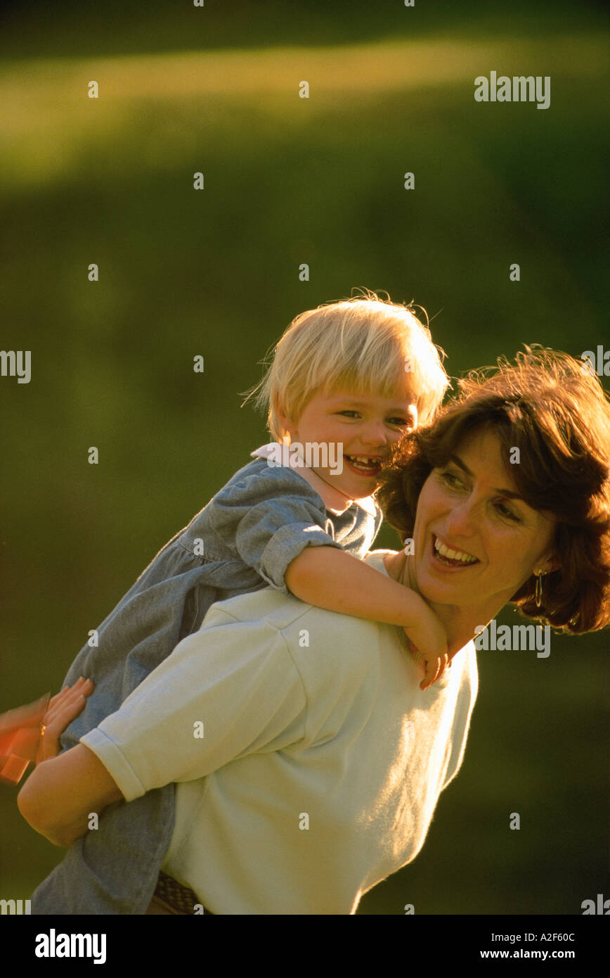 MOTHER CARRYING TODDLER DAUGHTER Stock Photo